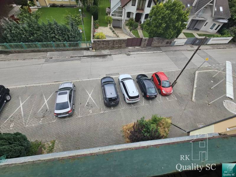 SENEC - NA PREDAJ EXKLUZÍVNE IBA U NÁS zariadený 3 izbový byt s vlastn - Parkovisko na Kysuckej ulici v Senci s piatimi zaparkovanými autami pri 3-izbovom byte.