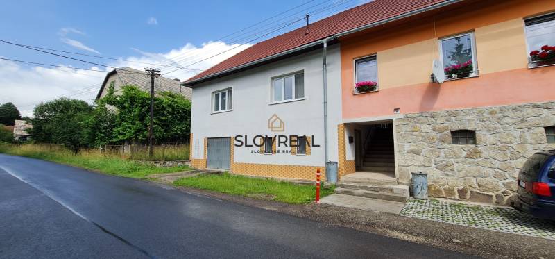 ✅ SLOVREAL Predaj rodinného domu kúsok od mesta Kremnica - Kopernica - **Rodinný dom** so šikmou strechou a farebnou fasádou pri ceste v obci.