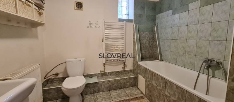 ✅ SLOVREAL Predaj rodinného domu kúsok od mesta Kremnica - Kopernica - Kúpeľňa s vaňou a toaletou, bielo-zelené obklady v rodinnom dome.