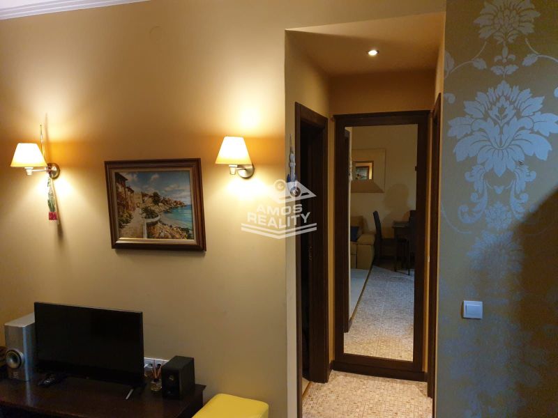 Predaj, 2 i apartmán 72 m2 + balkón výhľad na more, Burgas, BULHARSKO - Rekreačný apartmán so svetlou tapetou, obrazom a televízorom na nábytku.