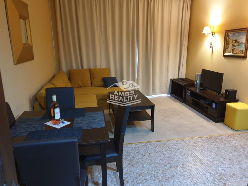 Predaj, 2 i apartmán 72 m2 + balkón výhľad na more, Burgas, BULHARSKO - Obývacia izba Rekreačného apartmánu so žltou sedačkou, jedálenským stolom a televíziou.