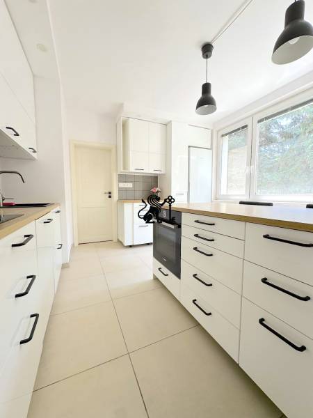 3 izbový byt  Borodáčová ulica, Bratislava - Ružinov - Poseň - Kuchyňa v 3-izbovom byte s bielymi skrinkami a čiernymi úchytkami.
