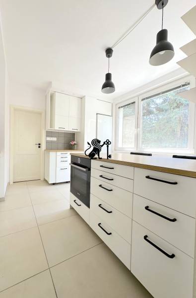 3 izbový byt  Borodáčová ulica, Bratislava - Ružinov - Poseň - Kuchyňa s bielymi skrinkami, čiernymi rúčkami a veľkým oknom v 3-izbovom byte.