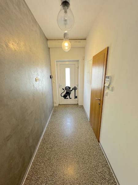 Rodinný dom A2 v Rači na ulici Pri vinohradoch - Úzka chodba so vstupnými dverami, jednoduché osvetlenie, na ulici Pri vinohradoch.