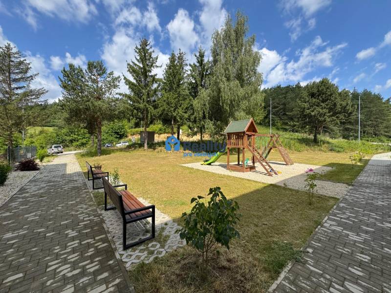 Prenájom NOVOSTAVBA FIM moderný byt 50 m2 + terasa 53 m2 PB - Detské ihrisko obklopené lavičkami a stromami v okolí Považskej Bystrice.