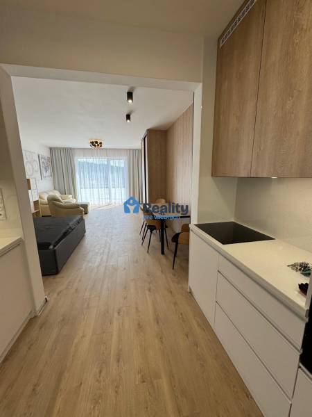 Prenájom NOVOSTAVBA FIM moderný byt 50 m2 + terasa 53 m2 PB - 2-izbový byt s otvorenou dispozíciou, drevené podlahy a biela kuchynská linka.