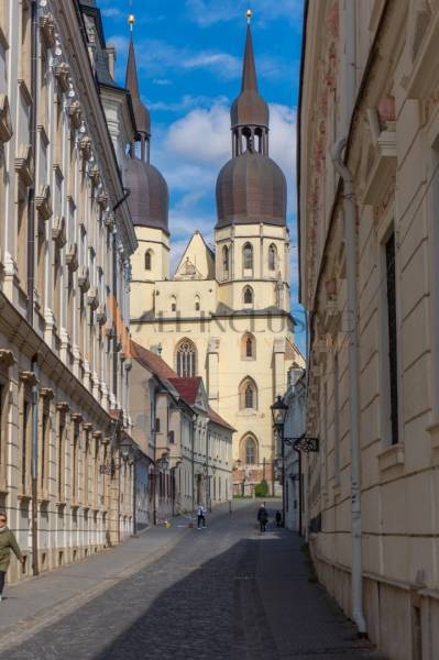 MEŠTIANSKY DOM | TRNAVA | CENTRUM - Ulica Hollého v Trnave so zvláštnymi nehnuteľnosťami a gotickým kostolom v pozadí.