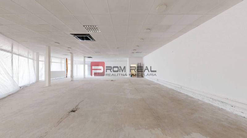 PREDAJ priestoru na frekventovanom mieste BRATISLAVA - Priestranné obchodné priestory so svetlými stenami a stropnými panelmi pripravené na zariadenie.