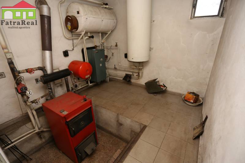 Rodinný dom po kvalitnej rekonštrukcii a prestavbe, Ľubochňa - Kotolňa v rodinnom dome, zahŕňajúca červený kotol, potrubia a nádrže na vykurovanie.