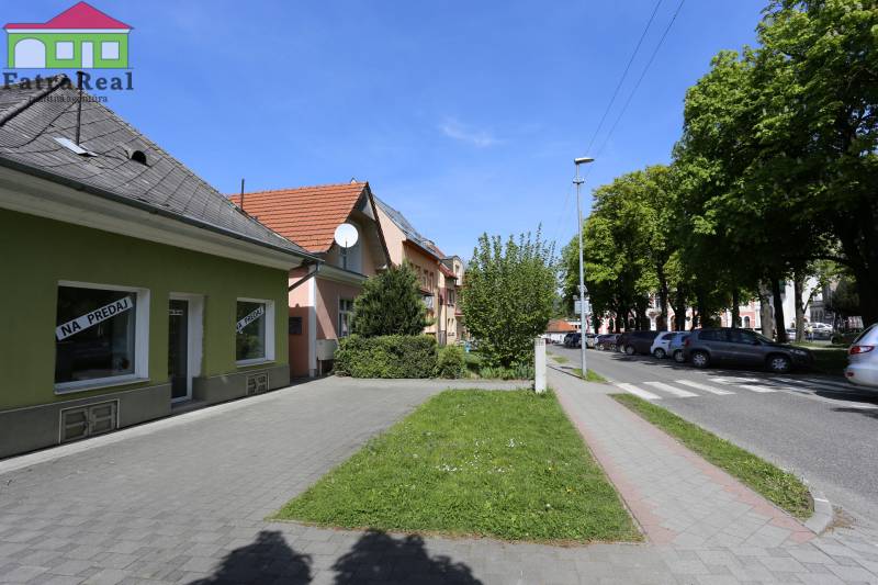 Rodinný dom v rekonštrukcii, Ružomberok - Na ulici Nám. A. Hlinku, rodinný dom, okolo sú autá a stromy.