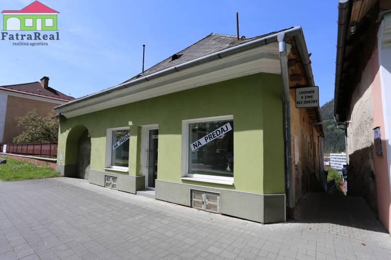 Rodinný dom v rekonštrukcii, Ružomberok - Rodinný dom na ulici Nám. A. Hlinku, určený na predaj, s nápisom a zelenou fasádou.