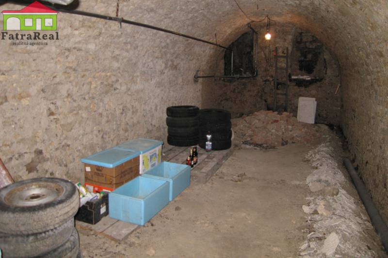 Rodinný dom v rekonštrukcii, Ružomberok - Sklep s pneumatikami a bedňami, na ulici Nám. A. Hlinku, vedľa rodinného domu.