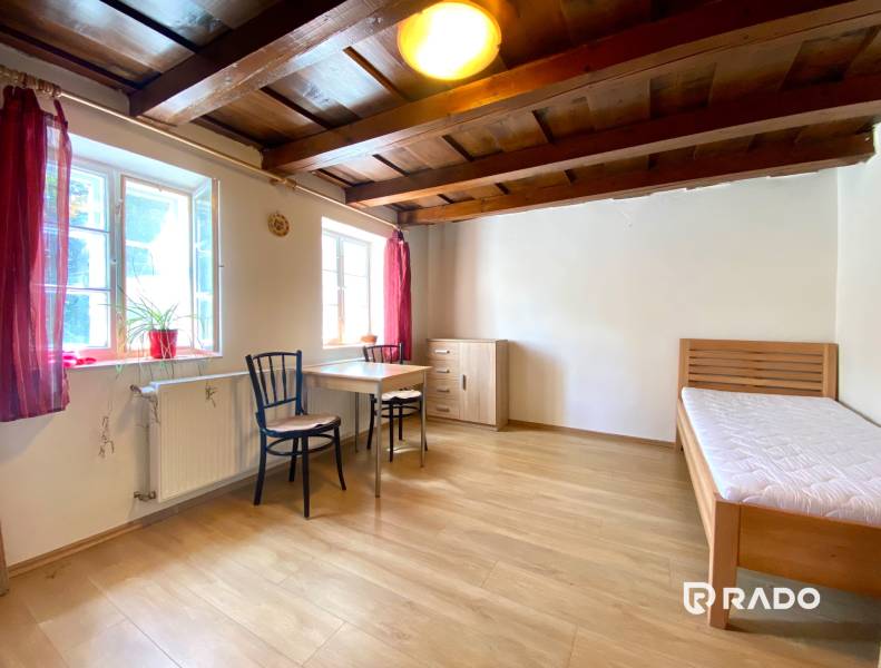 REZERVOVANÉ Garsónka 30m2 | Podunajské Biskupice - Garsónka so svetlým interiérom, nábytkom z dreva, stôl, stoličky a posteľ.