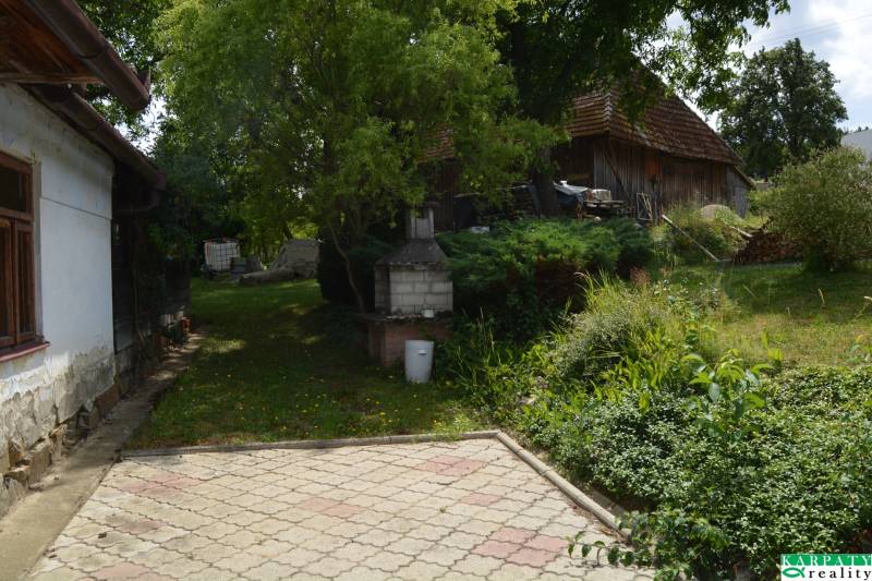 Chalúpka schúlená v okolitých ovocných sadoch! - Dvorek rodinného domu v Poriadí obklopený zeleňou s vonkajším krbom.