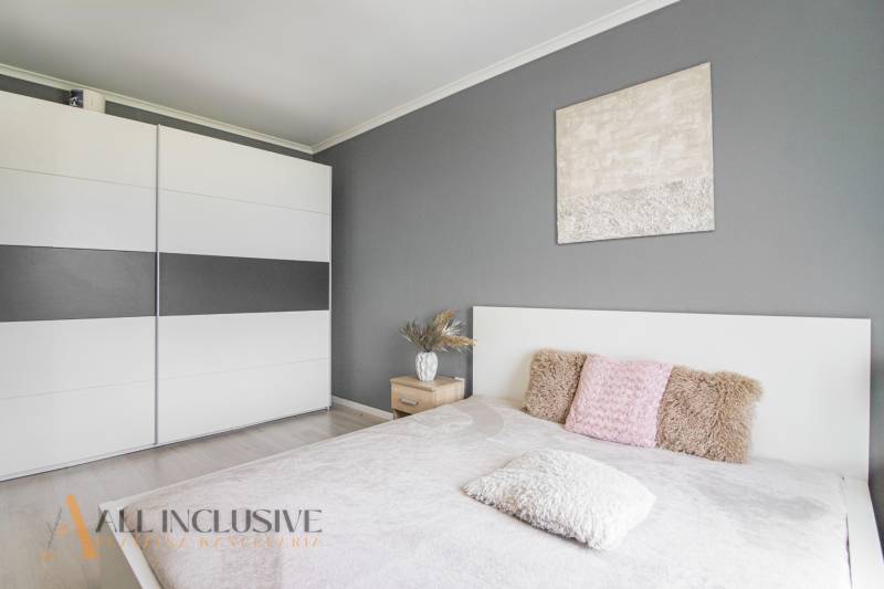 ALL INCLUSIVE REAL I KRÁSNY 2 IZBOVÝ BYT S BALKÓNOM GALANTA WEST - Spálňa v 2-izbovom byte so sivou stenou, skriňou a ozdobnými vankúšmi.