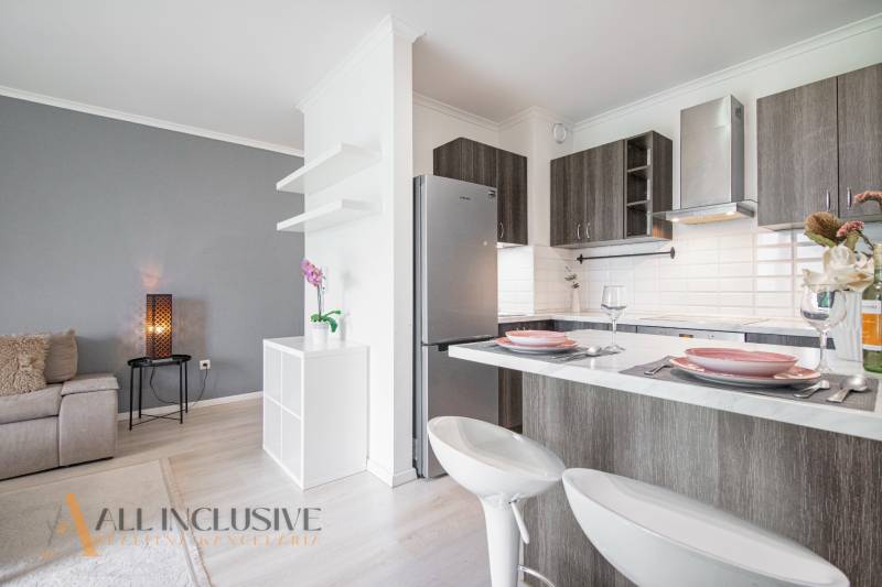 ALL INCLUSIVE REAL I KRÁSNY 2 IZBOVÝ BYT S BALKÓNOM GALANTA WEST - Kuchyňa v 2-izbovom byte s ostrovčekom, otvorená na obývačku so sivou stenou.