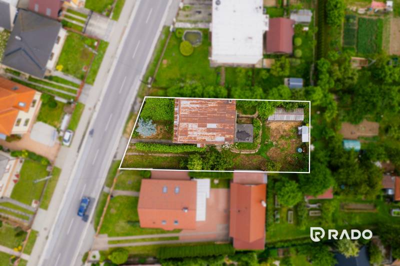 Na predaj Rodinný dom Drietoma – pozemok 745 m2  - Letecký pohľad na pozemok s rodinným domom v Drietome, obklopený ďalšími domami a záhradami.