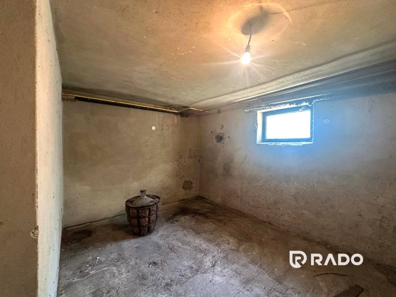 Na predaj Rodinný dom Drietoma – pozemok 745 m2  - Pivnica rodinného domu s hlinenou nádobou, betónová podlaha, malé okno.