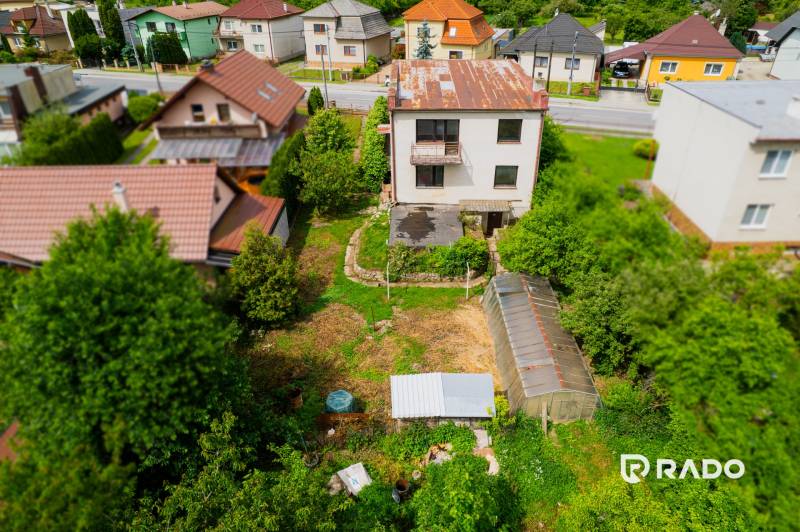 Na predaj Rodinný dom Drietoma – pozemok 745 m2  - Záber na rodinný dom v Drietome obklopený záhradou a stromami.