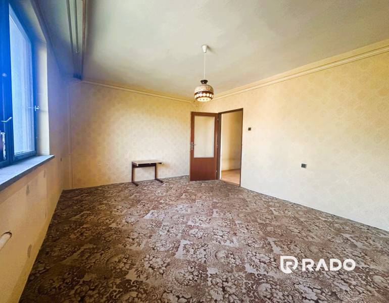 Na predaj Rodinný dom Drietoma – pozemok 745 m2  - Obývacia izba rodinného domu s kobercom, stolíkom a lustrom na strope.