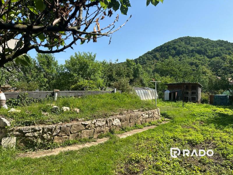 Na predaj Rodinný dom Drietoma – pozemok 745 m2  - Záhrada pri rodinnom dome v Drietome s výhľadom na lesnatý kopec a drevárňou.