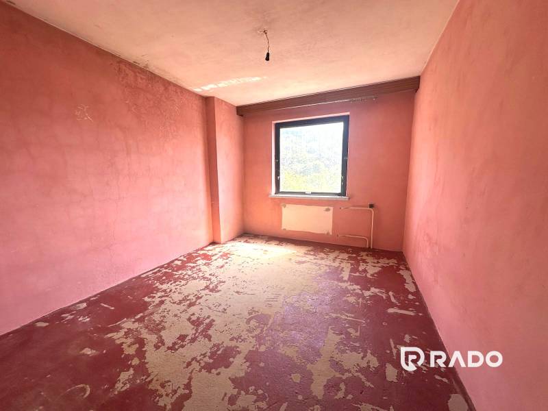 Na predaj Rodinný dom Drietoma – pozemok 745 m2  - Izba v rodinnom dome s ružovými stenami a starou dlážkou.