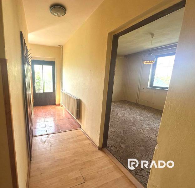 Na predaj Rodinný dom Drietoma – pozemok 745 m2  - Chodba so vstupnými dverami a otvorenými dverami do izby v rodinnom dome.
