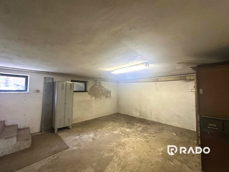 Na predaj Rodinný dom Drietoma – pozemok 745 m2  - Pivnica v rodinnom dome so skrinkou, schodmi a oknami, bez ďalších výrazných prvkov.