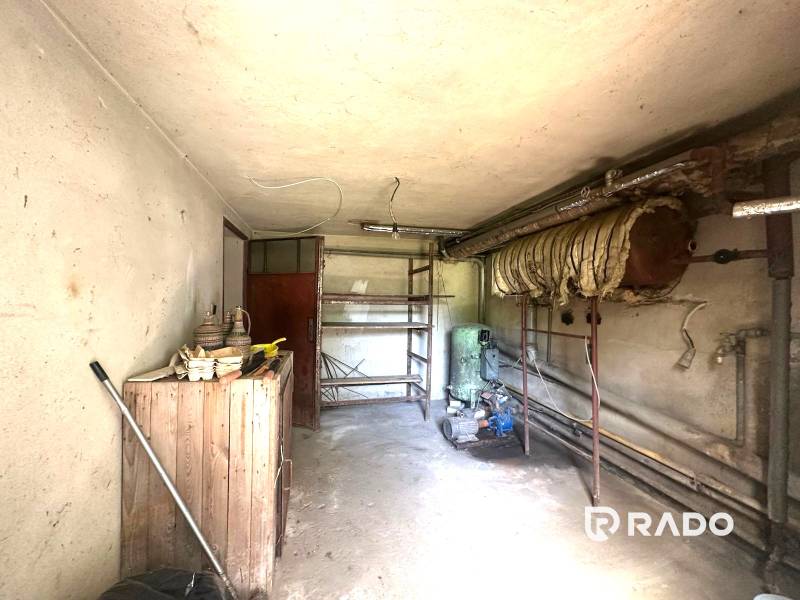 Na predaj Rodinný dom Drietoma – pozemok 745 m2  - Úložný priestor v rodinnom dome s regálmi a starým bojlerom.