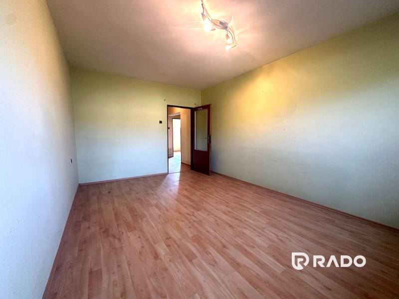 Na predaj Rodinný dom Drietoma – pozemok 745 m2  - Priestranná miestnosť s drevenou podlahou a svetlom zaveseným na strope v rodinnom dome.
