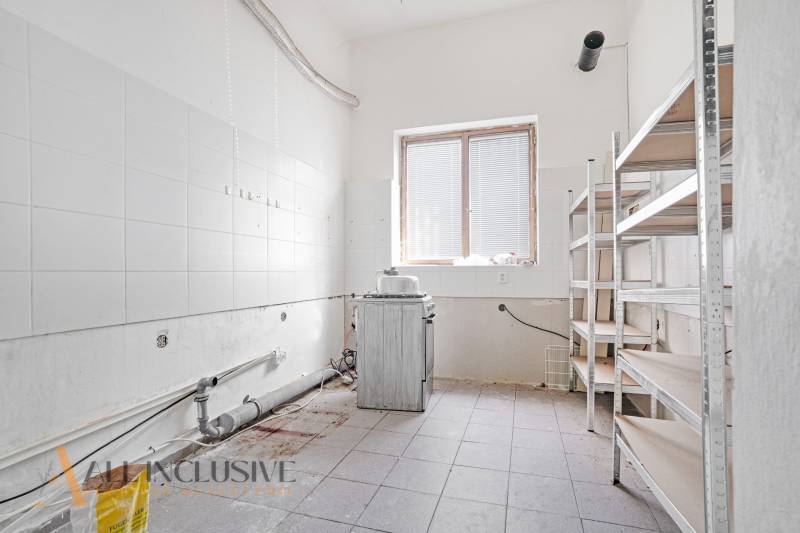NA PRENÁJOM OBCHODNÝ PRIESTOR V CENTRE,DUNAJSKÁ STREDA - Priestor s umývateľnými stenami, regálmi a zanedbaným zariadením v obchodných priestoroch.