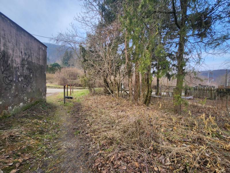 Stavebný pozemok 1001 m2 - Pozemky - bývanie na Majdane v Horných Orešanoch, lemované stromami a plotom.