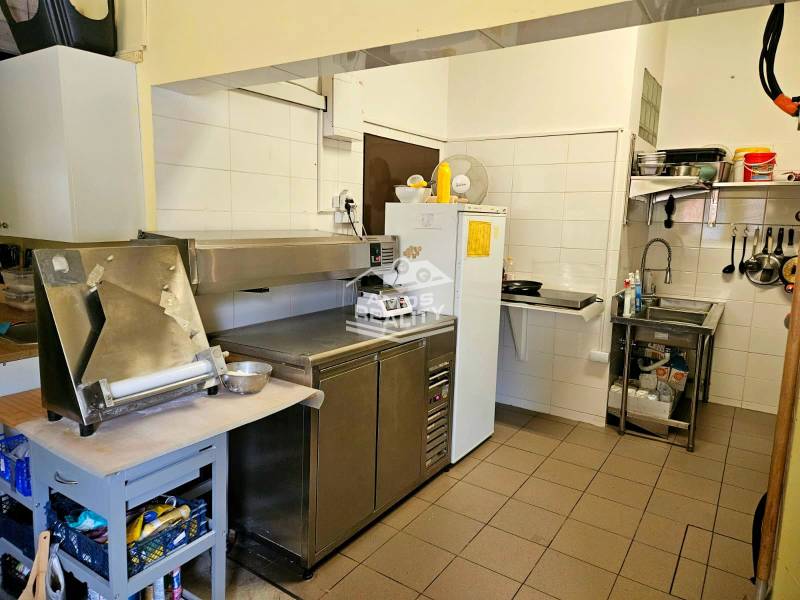 Predaj/odstúpenie zabehnutej gastro prevádzky s kuchyňou, Bratislava 2 - Kuchynské vybavenie v gastro priestore s nerezovými spotrebičmi a bielymi stenami.