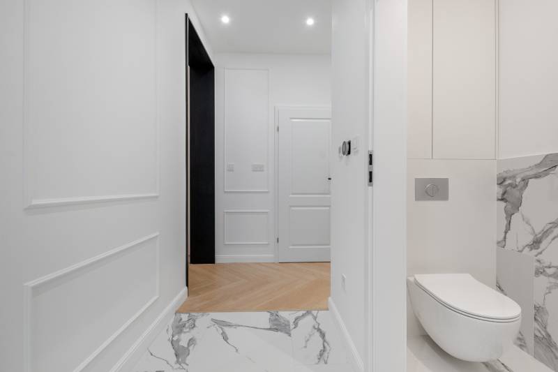 THE HOME ︱ PREDAJ - designový 5-izbový rodinný dom v Chorvátskom Grob - Interiér rodinného domu s bielymi stenami, drevenou podlahou a modernou toaletou.