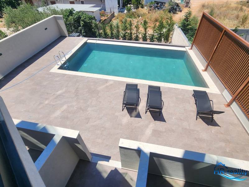 Ksamil – luxusné zariadené apartmány v Maledivách Európy - Rekreačný apartmán v Ksamil s bazénom a lehátkami na slnečnej terase.