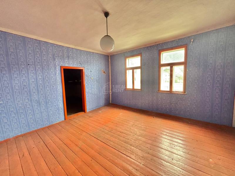 Predaj pôvodného charizmatického domu v Makove - Izba v rodinnom dome s drevenou podlahou a modrou tapetou.