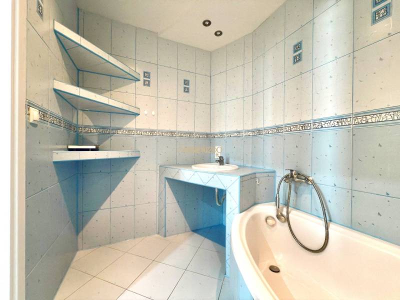 - EXKLUZÍVNE - PREDAJ - 3,5 IZBOVÝ BYT - LEVICE - Kúpeľňa so svetlomodrými kachličkami, vaňou a umývadlom v 4-izbovom byte.