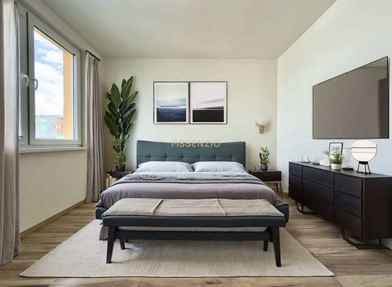 - EXKLUZÍVNE - PREDAJ - 3,5 IZBOVÝ BYT - LEVICE - Svetlá spálňa v 3-izbovom byte s veľkou posteľou, rastlinami a minimalistickým nábytkom.