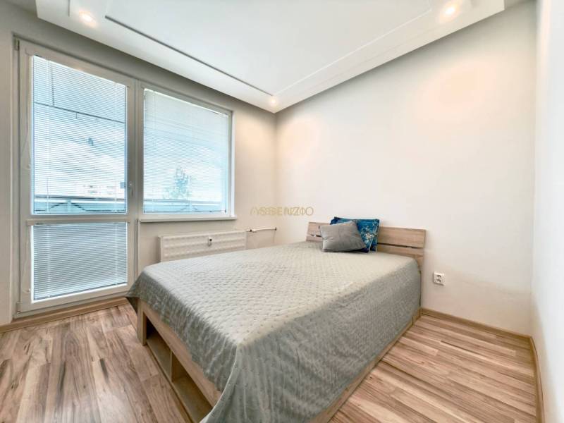 - EXKLUZÍVNE - PREDAJ - 3,5 IZBOVÝ BYT - LEVICE - Svetlá spálňa v 4-izbovom byte s laminátovou podlahou a jednoduchou posteľou.