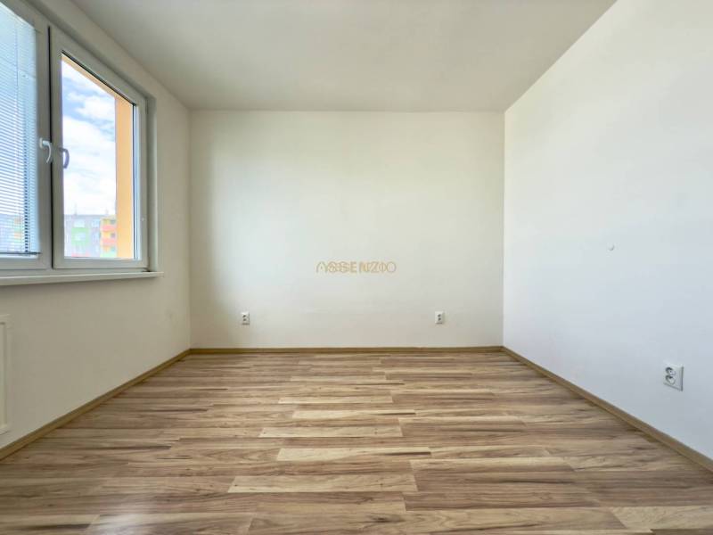 - EXKLUZÍVNE - PREDAJ - 3,5 IZBOVÝ BYT - LEVICE - Prázdna svetlá miestnosť s drevenou podlahou v 4-izbovom byte.