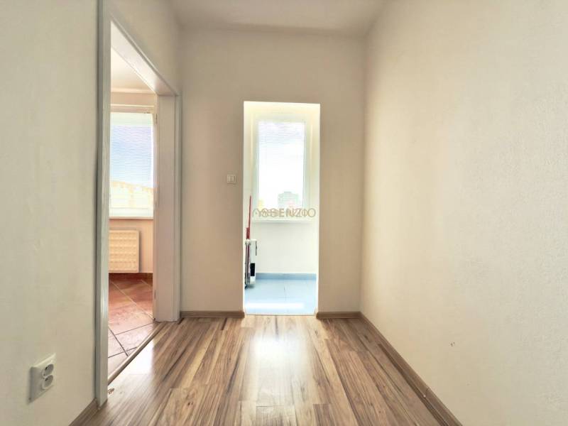 - EXKLUZÍVNE - PREDAJ - 3,5 IZBOVÝ BYT - LEVICE - Chodba 4-izbového bytu s drevenými podlahami a bielymi stenami.