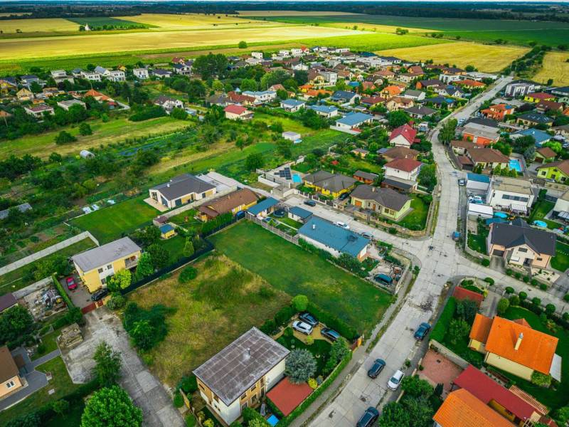 Priestranný pozemok neďaleko Bratislavy - Letecký pohľad na Priemyselnú ulicu v Novej Dedinke, okolité pozemky a domy, Pozemky - bývanie.