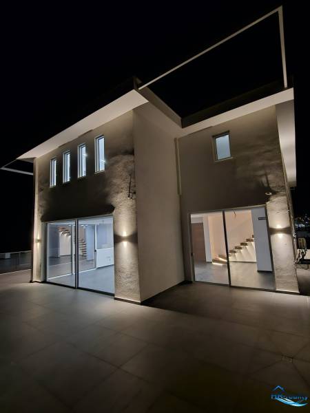  Albánsko, Sarandë – luxusné novostavby apartmánov v prvom rade - Exteriér rekreačného apartmánu v Sarandë osvetlený nočným svetlom.