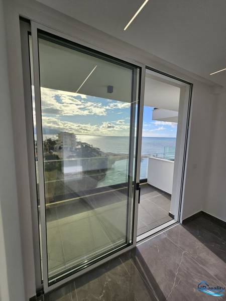  Albánsko, Sarandë – luxusné novostavby apartmánov v prvom rade - Sklenené posuvné dvere s výhľadom na more v rekreačnom apartmáne pri Sarandë.
