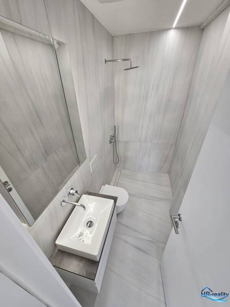  Albánsko, Sarandë – luxusné novostavby apartmánov v prvom rade - Kúpeľňa v Rekreačnom apartmáne so sprchovým kútom, umývadlom a toaletou.