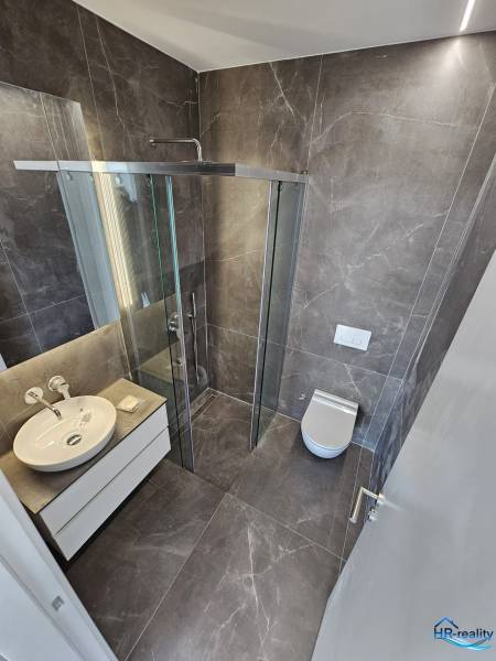  Albánsko, Sarandë – luxusné novostavby apartmánov v prvom rade - Kúpeľňa Rekreačného apartmánu s priestranným sprchovacím kútom a moderným vybavením.