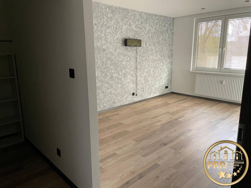 Na predaj krásny komplet prerobený, moderne zariadený 3-izb. byt v BnB - Prázdna miestnosť v 3-izbovom byte s drevenou podlahou a štrukturálnou stenou.