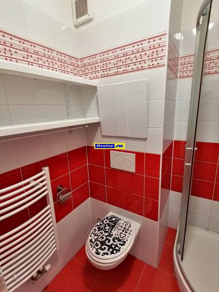 2 izbový byt na prenájom Vrútky, balkón - Kúpeľňa v 2-izbovom byte s výraznými červenými a bielymi obkladmi.