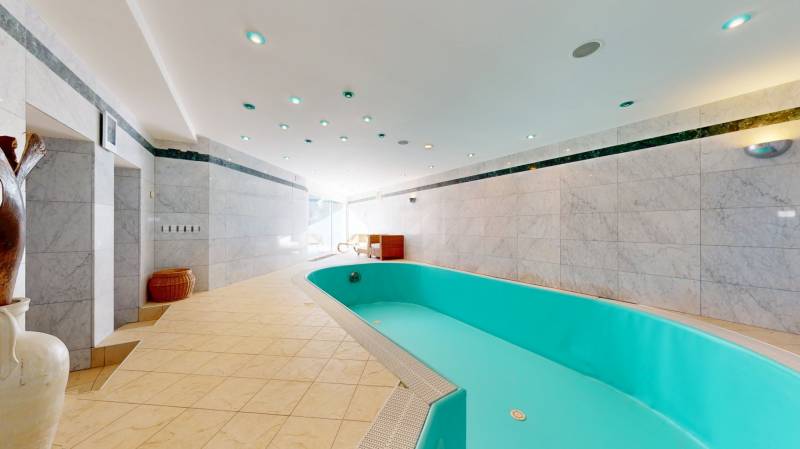 6-izbový rodinný dom s wellness a bazénom Záhorská Bystrica - Vila s vnútorným bazénom, obklopená svetlými dlaždicami a moderným osvetlením.