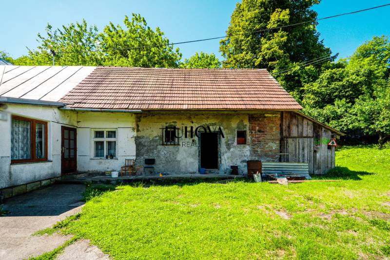 Rodinný dom na rekonštrukciu_Lúky - Rodinný dom v Lúkach na ulici Lúky s tradičnou strechou a zeleným exteriérom.
